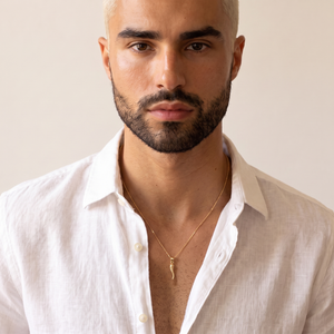 10K yellow gold Italian horn pendant worn by a man with an open-collar shirt